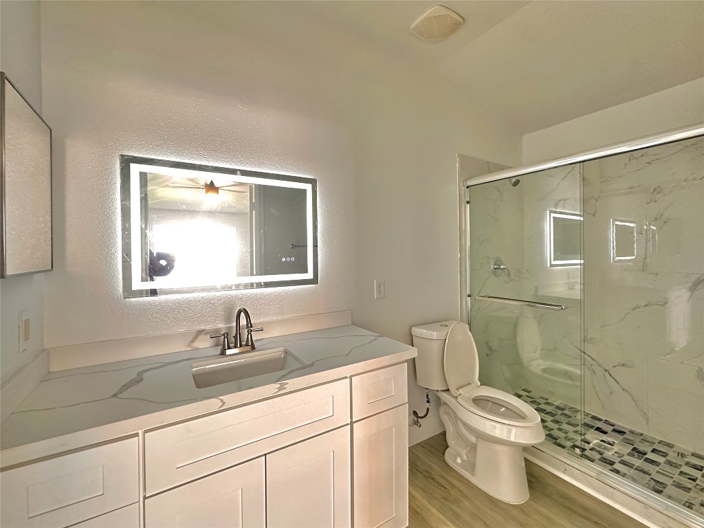 8202 Radial Court Rosharon, TX 77583 - Photo 18 of 27 a bathroom with a granite countertop sink a toilet and a mirror
