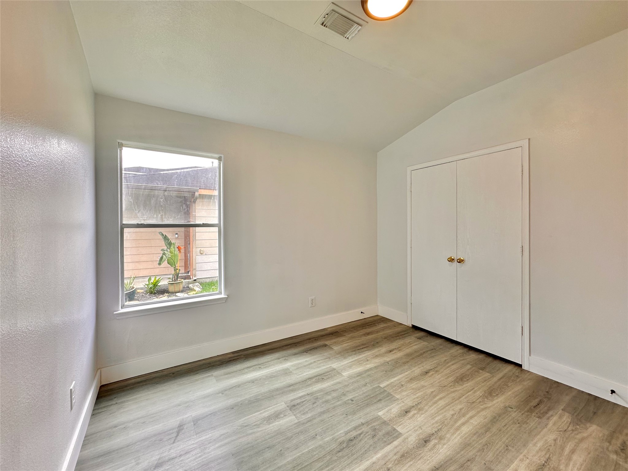 8202 Radial Court Rosharon, TX 77583 - Photo 20 of 27 an empty room with wooden floor and windows