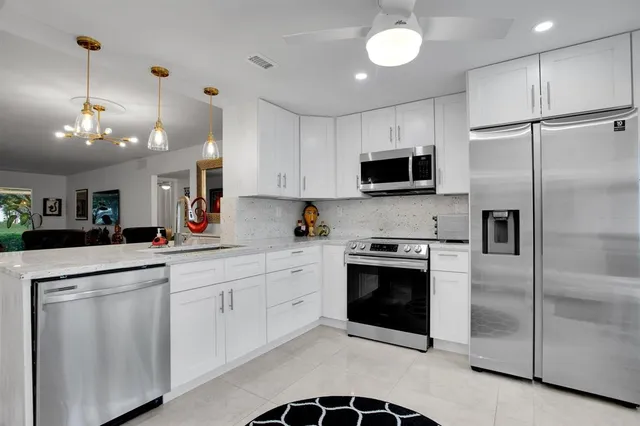 a kitchen with cabinets stainless steel appliances and a counter top space