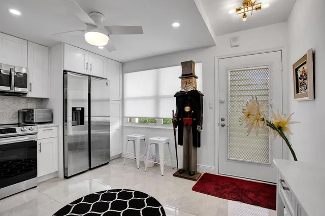 a kitchen with stainless steel appliances granite countertop a refrigerator a stove and a sink