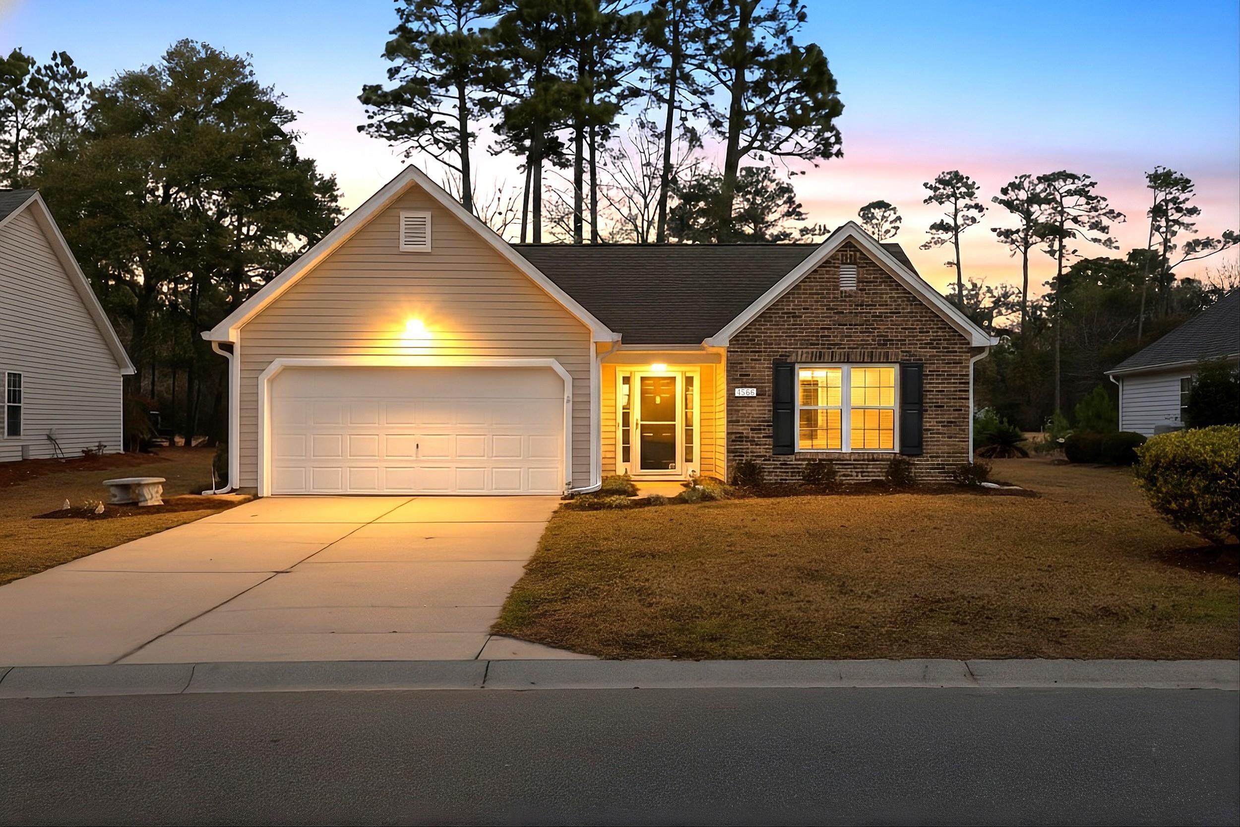 View of front of home featuring concrete driveway, a garage, and a front yard