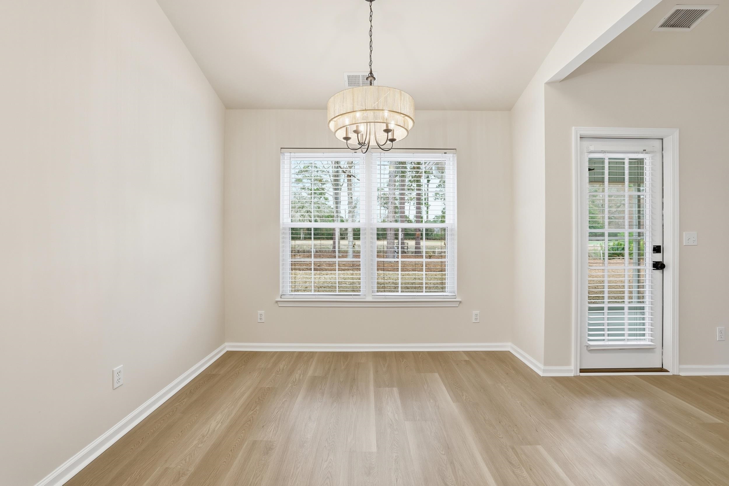 4566 Fringetree Drive Murrells Inlet, SC 29576 - Photo 9 of 36 Unfurnished dining area with light wood-style floors and a chandelier