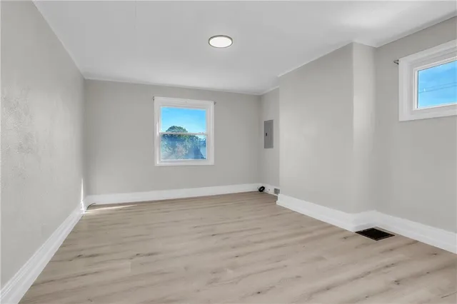 an empty room with wooden floor and white walls