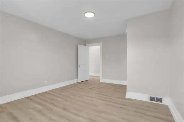 a view of a hallway with wooden floor and closet