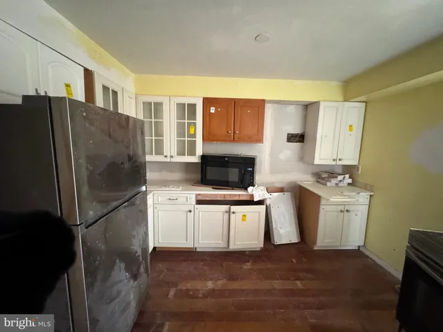 a kitchen with stainless steel appliances granite countertop a refrigerator a stove and a sink