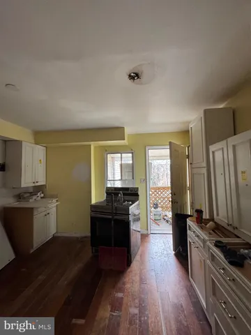 a kitchen with granite countertop a stove top oven a sink dishwasher and wooden floor