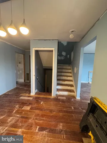 a view of a livingroom with wooden floor and stairs