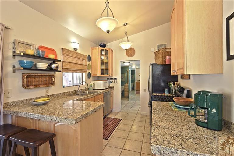 71586 Biskra Road Rancho Mirage, CA 92270 - Photo 9 of 25 a kitchen with stainless steel appliances granite countertop a sink a stove counter space and cabinets