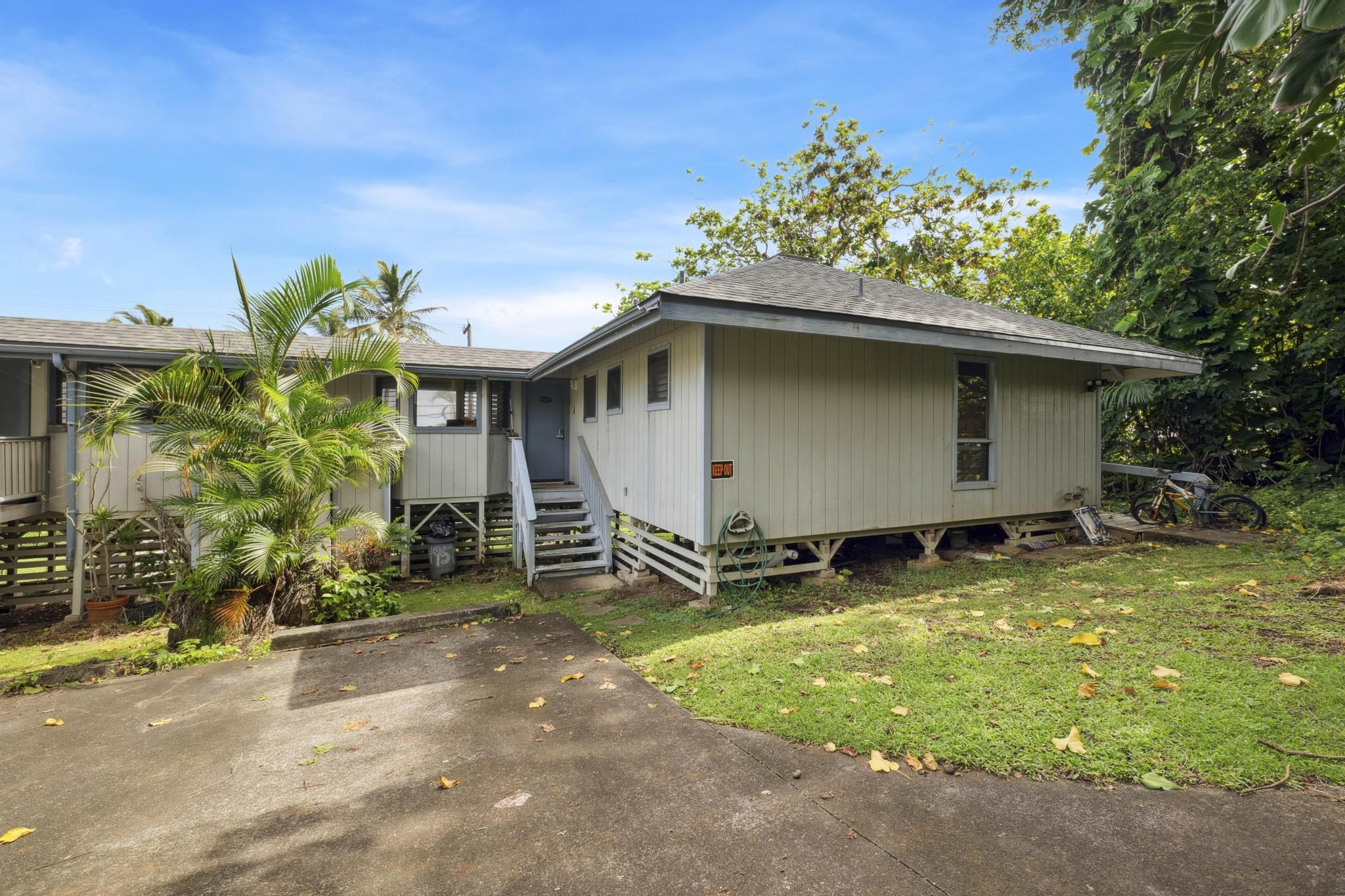 4950 Uakea Road Hana, HI 96713 - Photo 29 of 39 a backyard of a house with table and chairs under an umbrella