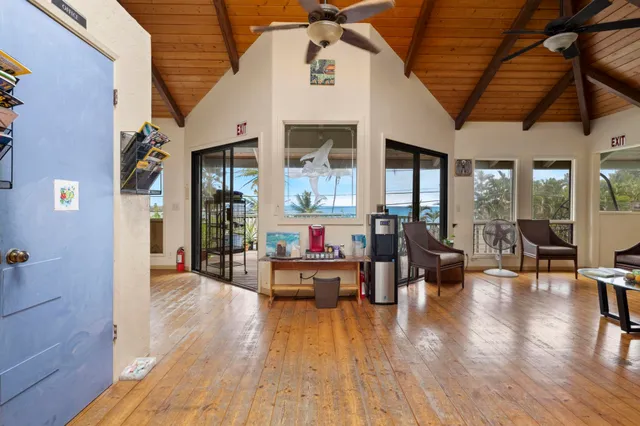 a living room with furniture floor to ceiling window and wooden floor