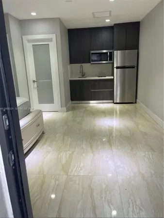 a view of kitchen with microwave and refrigerator