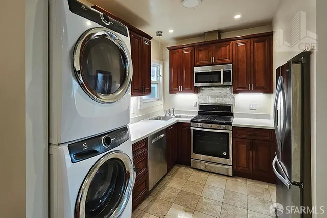 a kitchen with stainless steel appliances granite countertop a washer and dryer