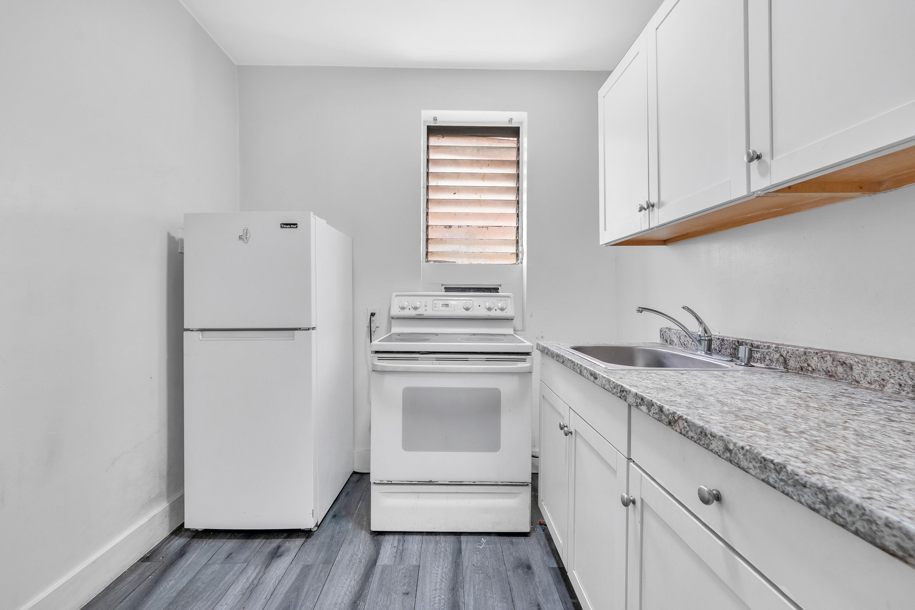 1554 Southwest 5th Street, Unit 5B Miami, FL 33135 - Photo 6 of 13 a kitchen with a sink cabinets stainless steel appliances and a window