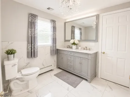 a spacious bathroom with a double vanity sink a toilet and a mirror