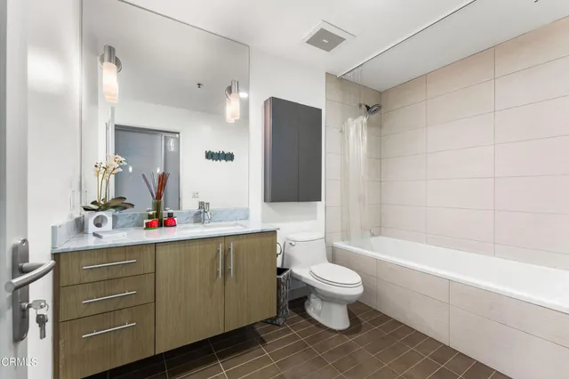 a bathroom with a bathtub sink vanity mirror and toilet