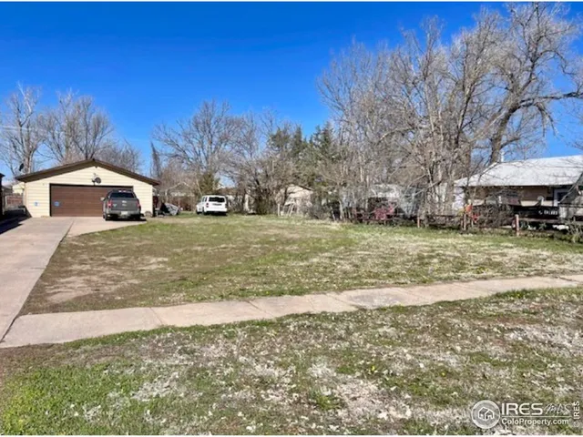 a view of a yard with a house in the background