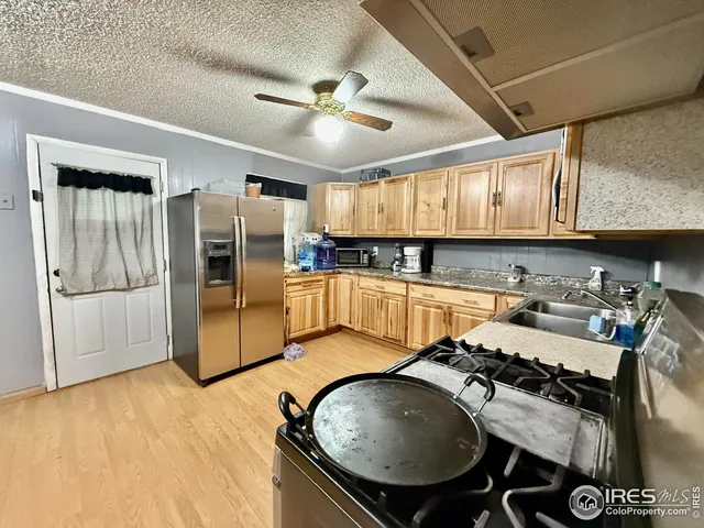 a kitchen with stainless steel appliances granite countertop a sink refrigerator and cabinets