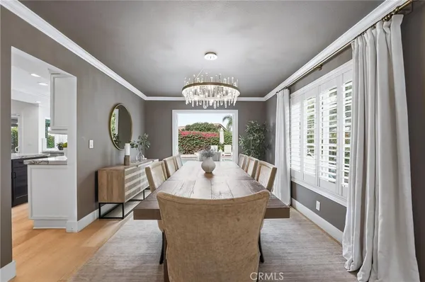 a dining room with furniture a chandelier and wooden floor