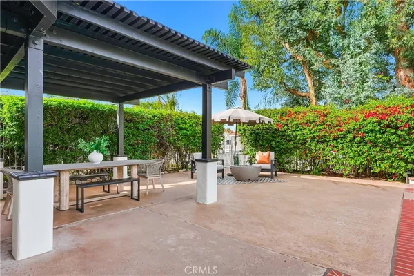 a view of the patio with dining table and chairs under an umbrella