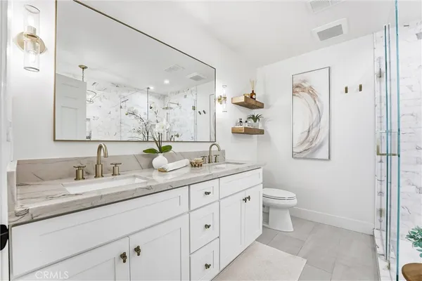 a bathroom with a granite countertop sink mirror and toilet