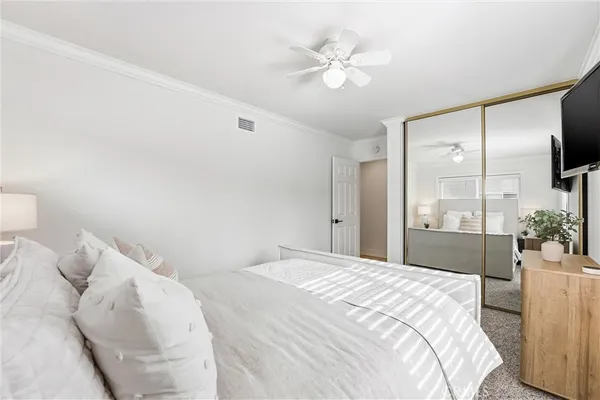 a bedroom with a large bed and a chandelier