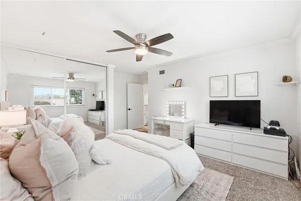a bedroom with a bed window and a flat screen tv