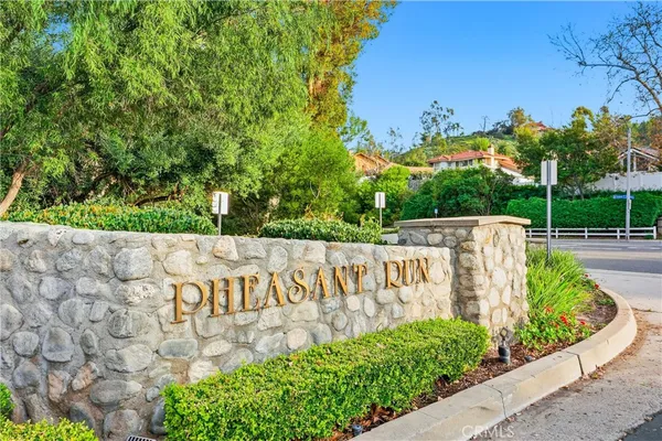 a view of a sign with a garden in the background