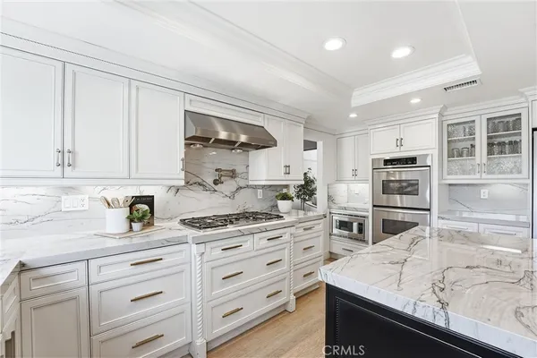 a kitchen with stainless steel appliances kitchen island sink refrigerator and cabinets