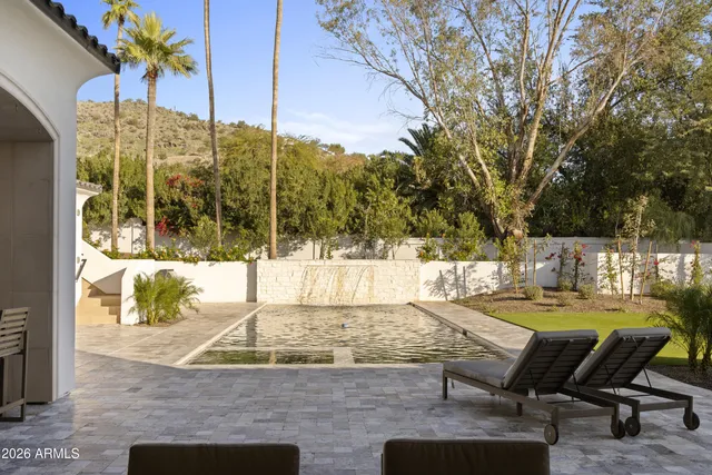 a kitchen with stainless steel appliances granite countertop a stove a sink and a refrigerator with wooden floor