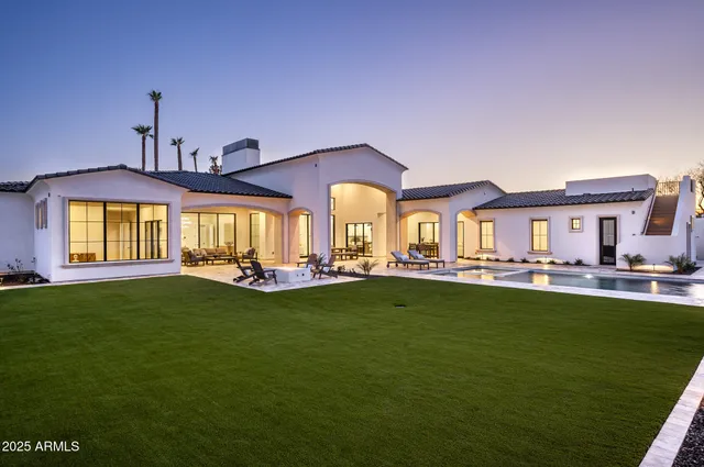 a view of a white house with a yard and sitting area