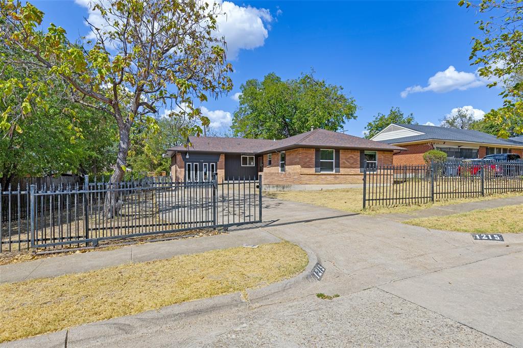 1215 Fordham Road Dallas, TX 75216 - Photo 1 of 25 Brick exterior residence with a brown shingle roof, black wrought iron fencing, and a concrete driveway