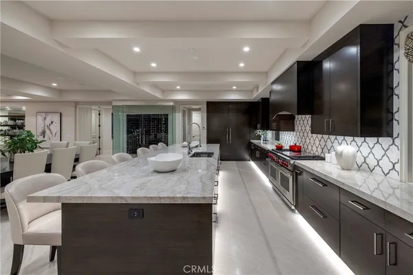 a large kitchen with granite countertop lots of counter space sink and a refrigerator
