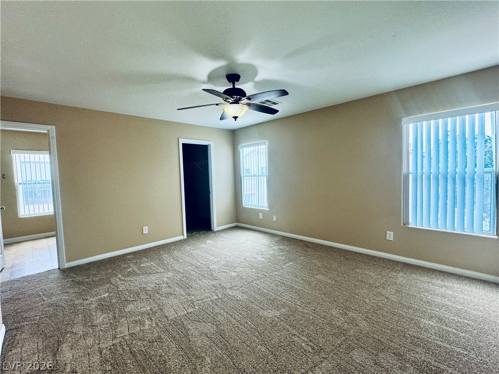 8617 Palomino Ranch Street Las Vegas, NV 89131 - Photo 20 of 27 A spacious bedroom offers comfort with plush carpeting and natural illumination through multiple windows.