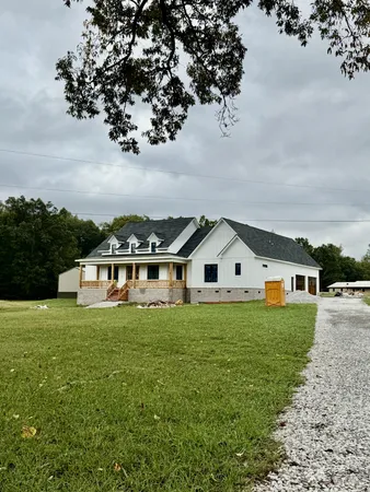 a view of a house with a big yard and large trees