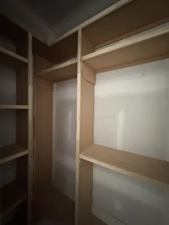 a view of an empty room with a kitchen