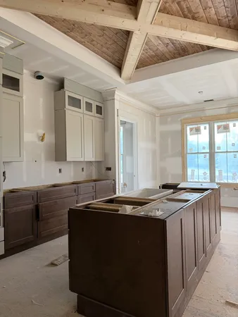 a kitchen with granite countertop a sink stove and cabinets