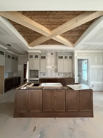 a view of an empty room with a window and a kitchen