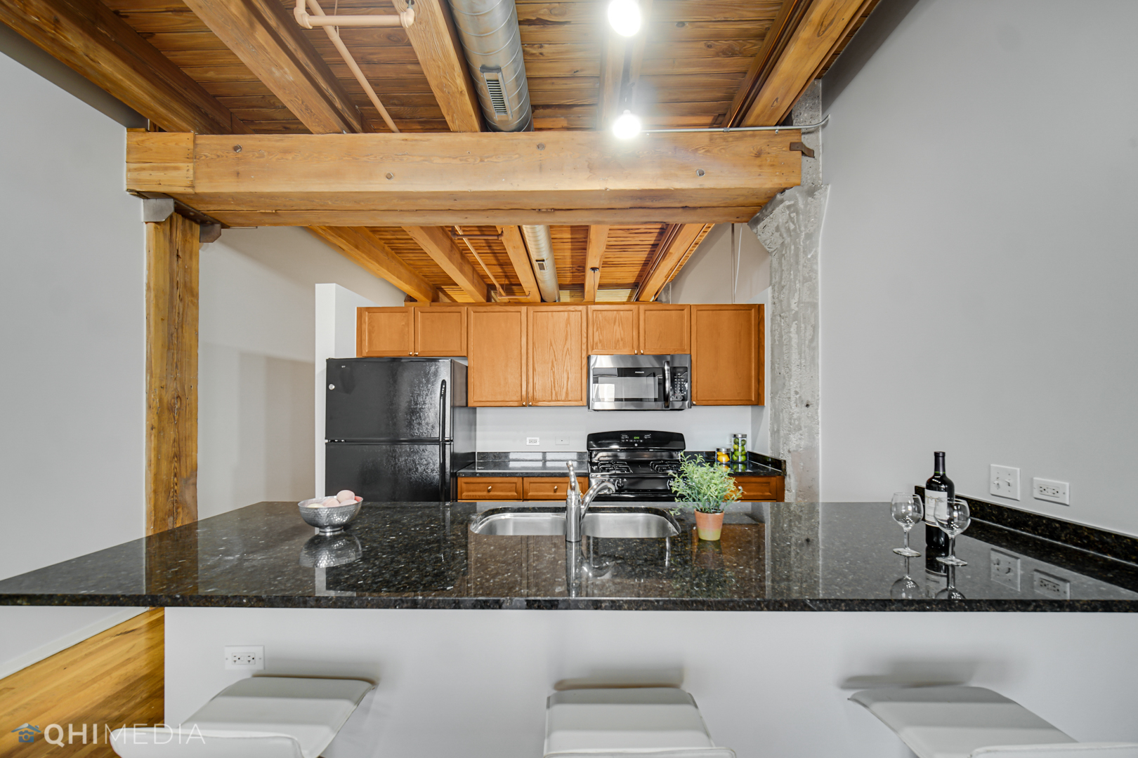 333 South Desplaines Street, Unit 314 Chicago, IL 60661 - Photo 7 of 22 a kitchen with stainless steel appliances kitchen island granite countertop a sink stove and cabinets