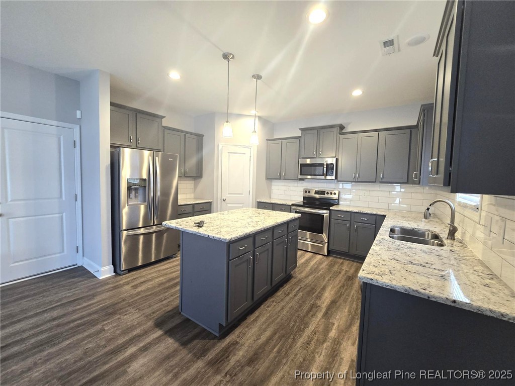 604 Amusement Drive Hope Mills, NC 28348 - Photo 14 of 41 a kitchen with stainless steel appliances granite countertop wooden cabinets a refrigerator a sink a stove a microwave and wooden floors