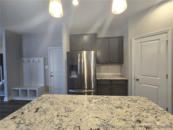 a kitchen with a refrigerator and a wooden floor