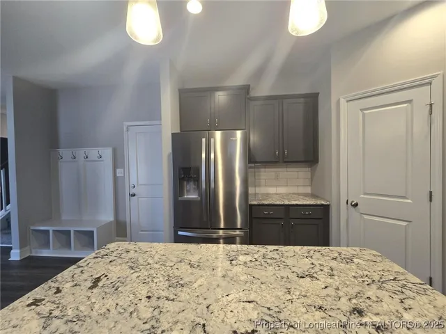 a kitchen with a refrigerator and a wooden floor