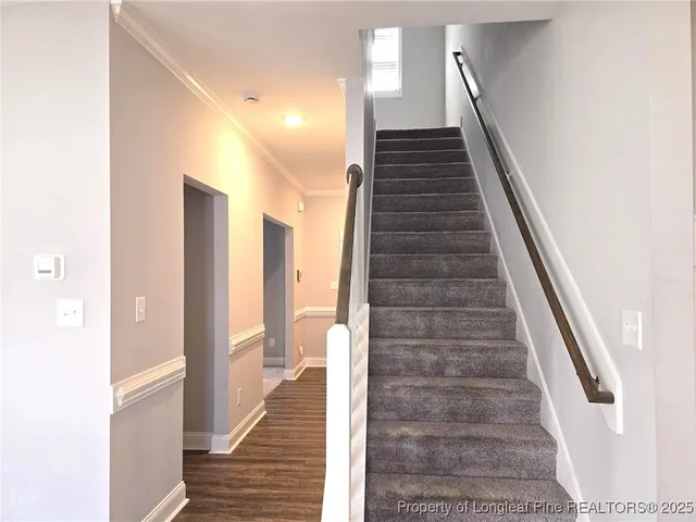 a view of a hallway with wooden floor and staircase