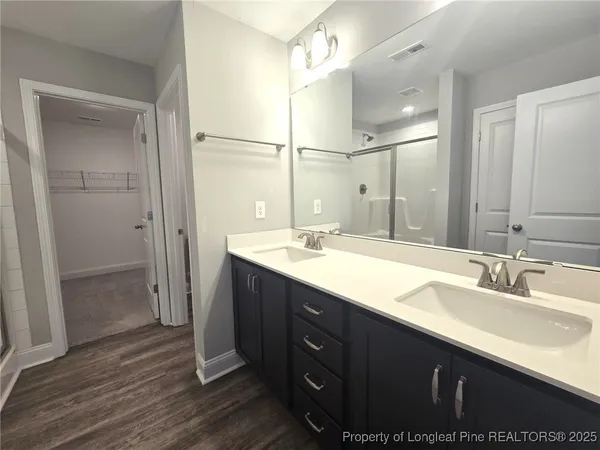 a bathroom with a double vanity sink mirror and shower
