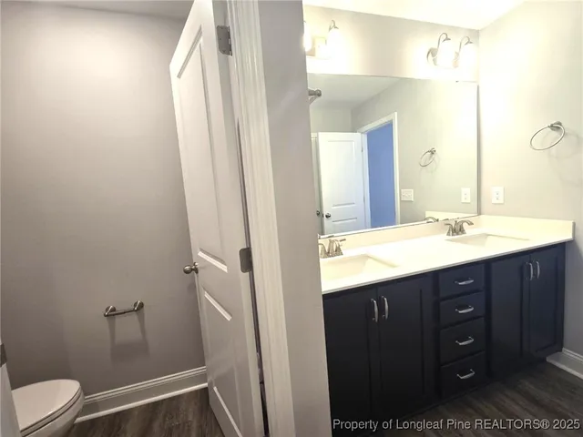 a bathroom with a sink vanity mirror and toilet
