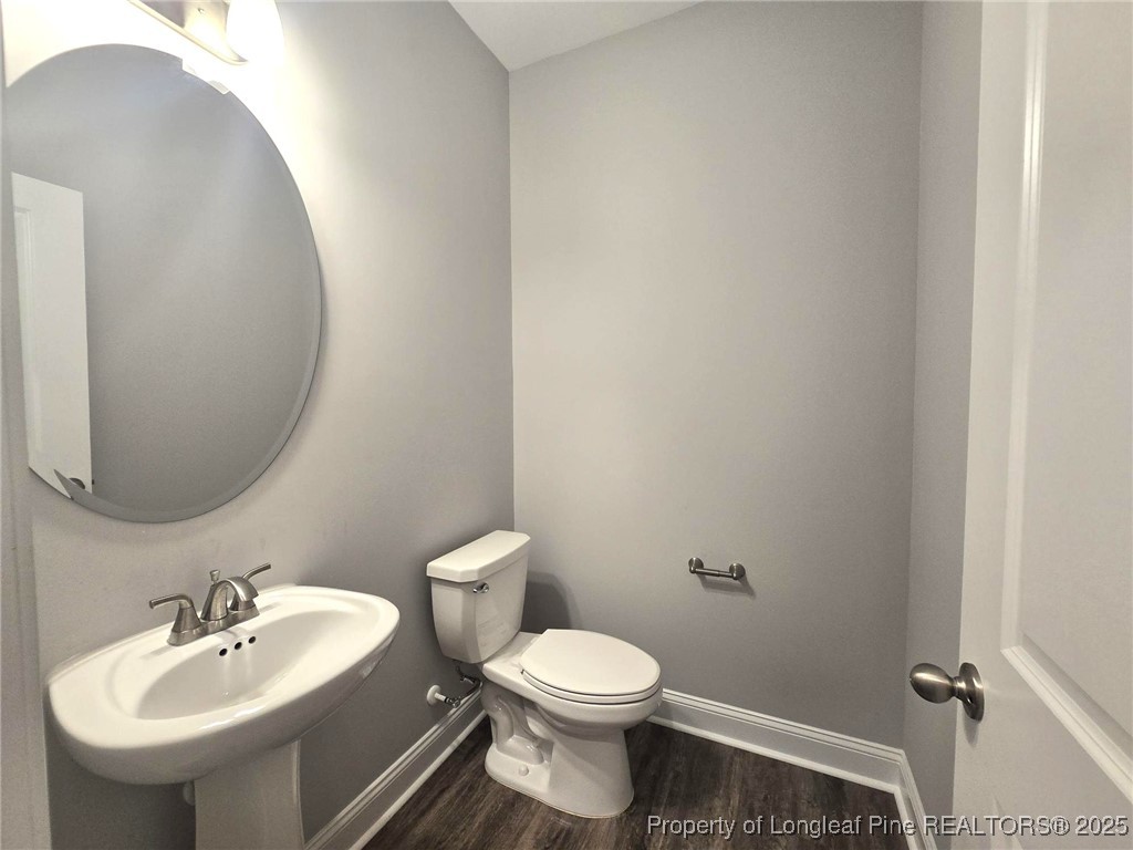 604 Amusement Drive Hope Mills, NC 28348 - Photo 8 of 41 a bathroom with a toilet sink and mirror