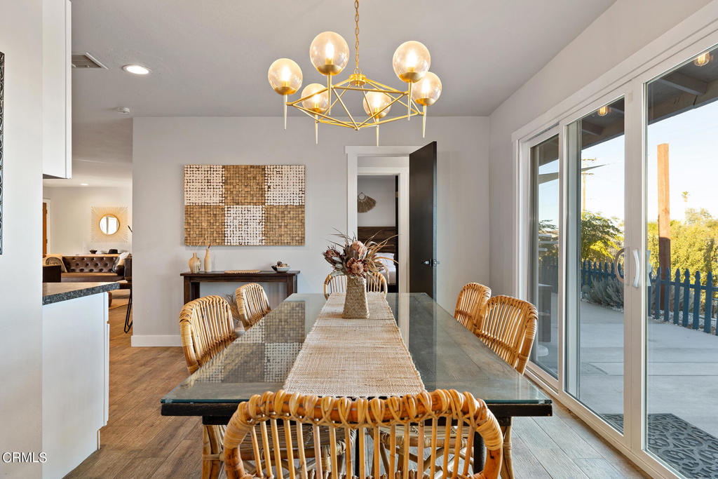 4741 Avenida Del Sol Joshua Tree, CA 92252 - Photo 11 of 52 a view of a dining room with furniture a chandelier and wooden floor