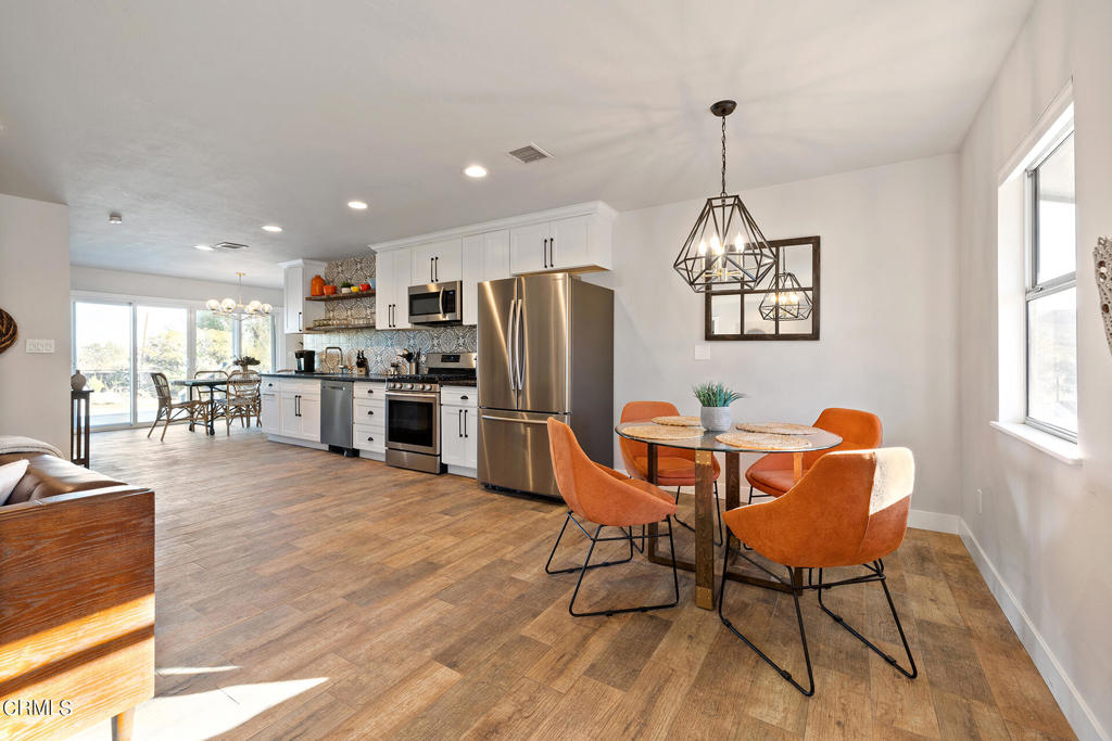 4741 Avenida Del Sol Joshua Tree, CA 92252 - Photo 16 of 52 a dining room with furniture a chandelier and wooden floor