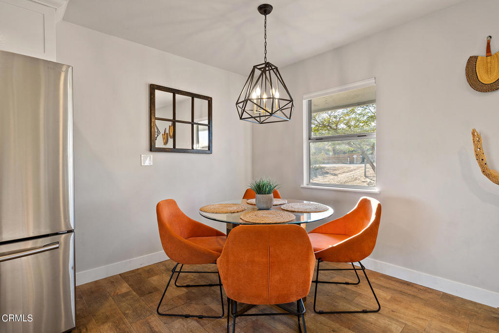 4741 Avenida Del Sol Joshua Tree, CA 92252 - Photo 17 of 52 a dining room with furniture a chandelier and wooden floor