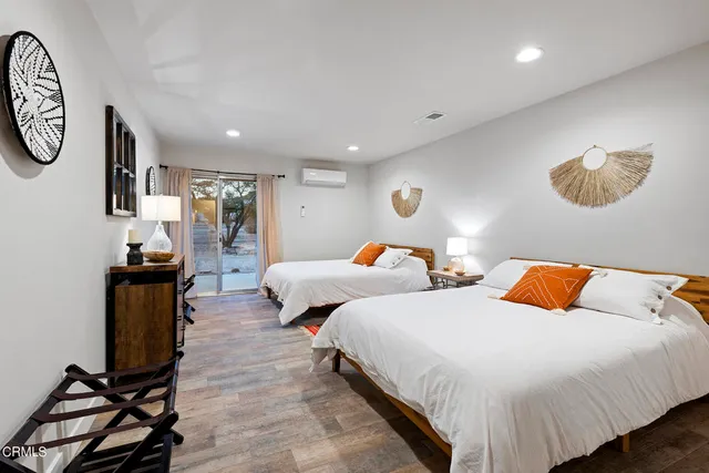 a bedroom with two beds and painting on the wall