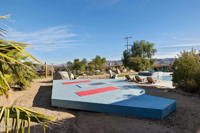a view of a house with backyard and chairs